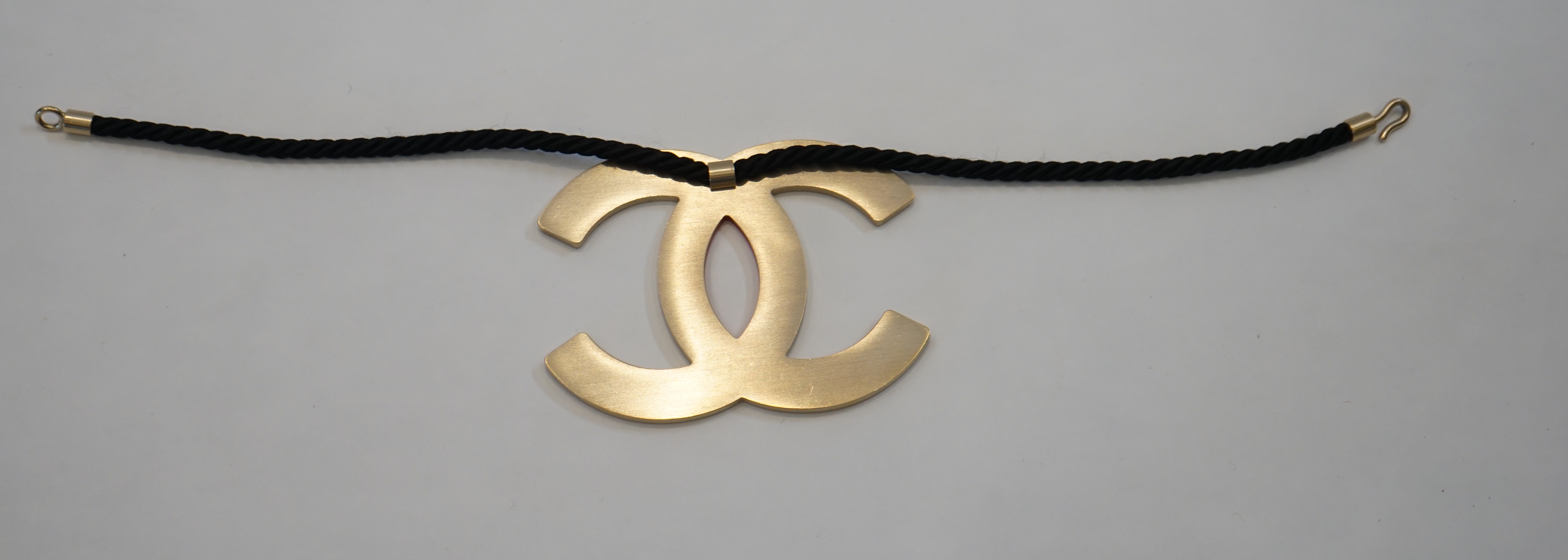 A Chanel CC red metal enamel and gold hardware fabric large choker evening necklace, cord length 39.5cm, charm width 10.75cm, height 8.25cm